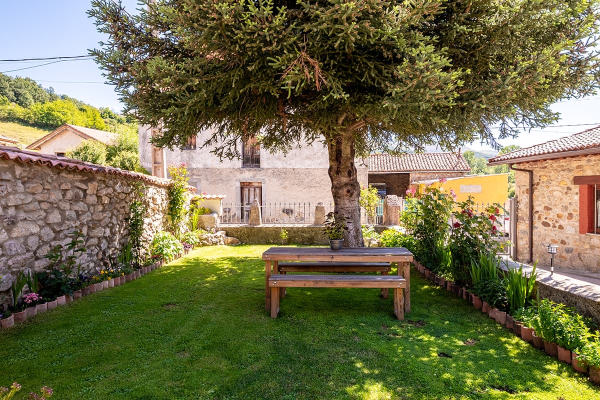Giardino privato di Casa Acebo con tavolo sotto un albero