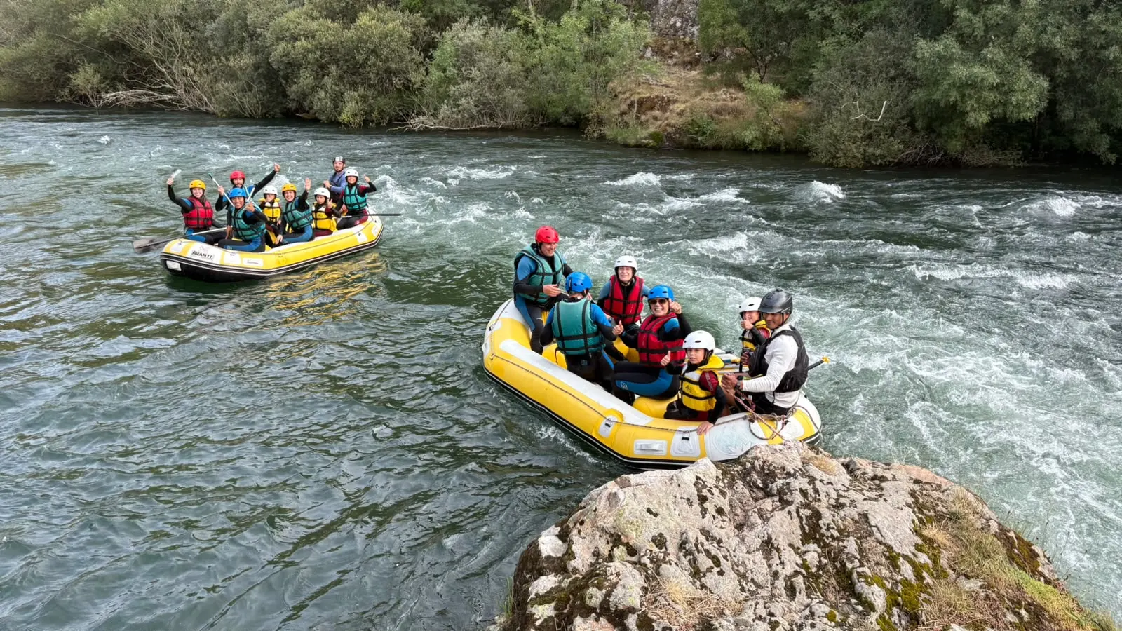 Dos balsas de rafting con adultos y niños junto a unos rápidos del río Esla.
